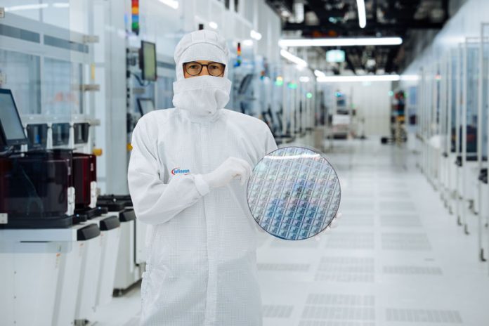 Ein Techniker im Reinraum von Infineon Technologies in Villach mit einem 300-Millimeter-Galliumnitrid-Wafer. Fotos: Infineon